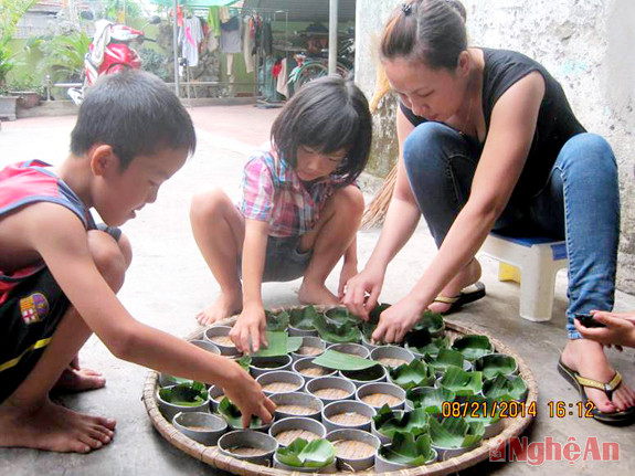 Mẹ con chị Liễu xếp lá vào khuôn đựng bánh.