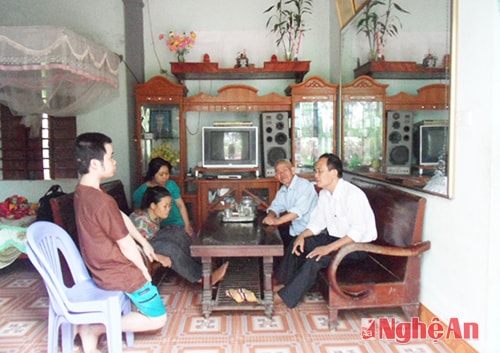 Ông Hồ Xuân Lương (phải) thăm nạn nhân chất độc da cam.