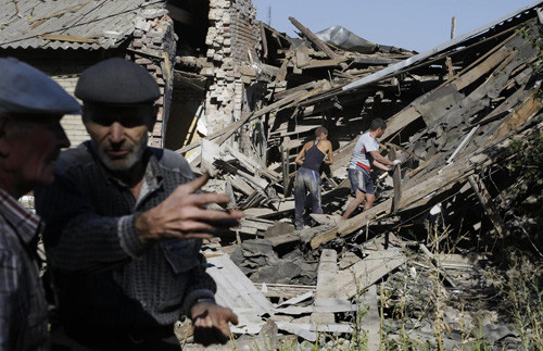 Người dân thị trấn Ilovaisk, đông Ukraine, giữa đống đổ nát của tòa nhà bị pháo kích hôm 31/8. Ảnh: Internet