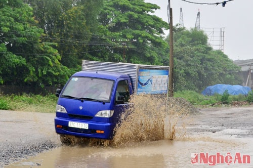 Quốc lộ 1A đang thi công giang dở, nhiều ổ voi, ổ gà bị ngập nước khiến phương tiện giao thông qua lại rất vất vả.