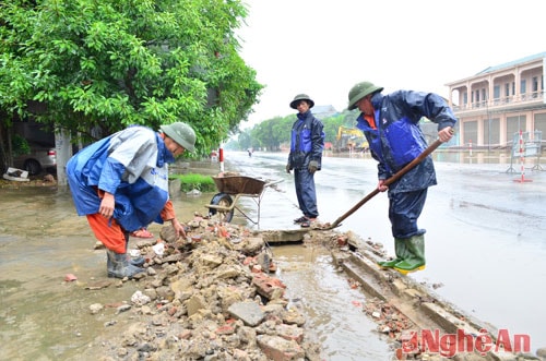 Công nhân Công ty xây dựng giao thông 486 nạo vét cống rãnh để khơi thông ngập úng đoạn cầu vượt đường sắt ngã 4 Quán Bánh.