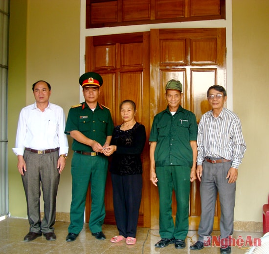 Đồng chí Nguyễn Hữu Trị - Phó bí thư Đảng ủy – Chính trị viên Ban CHQS huyện Hưng Nguyên trao chìa khóa căn nhà tình nghĩa cho gia đình.