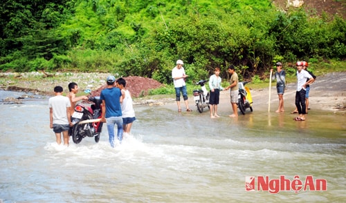 Người dân bản Xốp Tụ vận chuyển phương tiện qua cầu tràn km9.