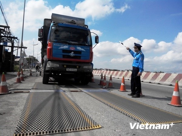 Lực lượng Thanh tra giao thông tiến hành kiểm tra trọng tải xe. Ảnh: Vietnam+