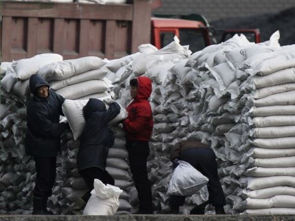 Người dân Triều Tiên phân phối các bao bột mỳ tại bờ sông Yalu. Nguồn: Reuters