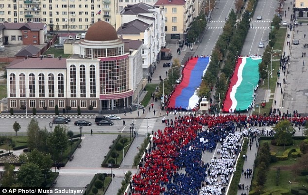 Tại Grozny, thủ đô nước cộng hòa Chechnya thuộc Nga, hàng trăm nghìn người mặc trang phục xanh, trắng, đỏ theo màu cờ Nga xếp thành hàng với chiều dài hơn 600 m và diễu hành quanh thành phố để chúc mừng sinh nhật lần thứ 62 của Tổng thống Nga Vladimir Putin. Ảnh: AP