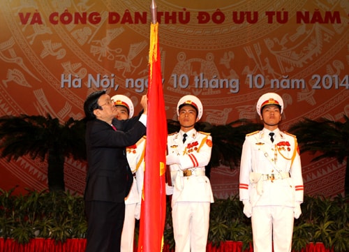 Chủ tịch nước Trương Tấn Sang gắn Huân chương Hồ Chí Minh lên lá cờ truyền thống của Thủ đô Hà Nội. Ảnh: Trí Dũng –TTXVN