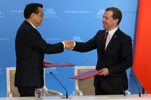 Thủ tướng Nga Dmitry Medvedev (phải) và Thủ tướng Trung Quốc Lý Khắc Cường trao đổi văn kiện hợp tác tại Moskva. Ảnh: AFP/ TTXVN
