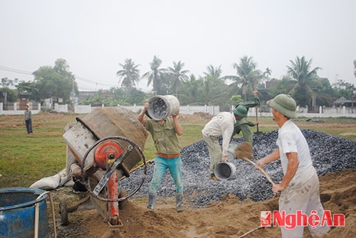 Công nhân đang tích cực trộn bê tông để thi công nhà hội trường văn hóa xã