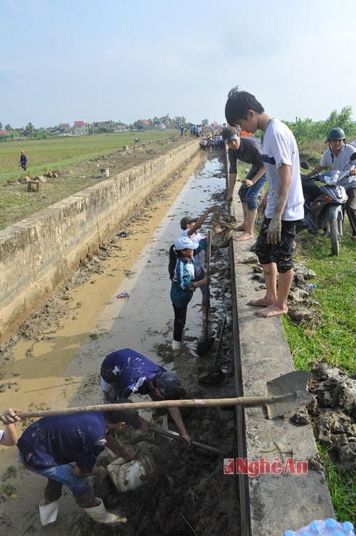 Các em học sinh được hướng dẫn kỹ thuật nạo vét mương tưới theo đúng quy trình