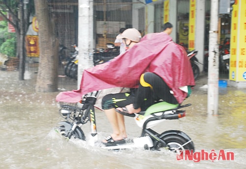 Học sinh băng qua những đoạn đường ngập úng để đến trường