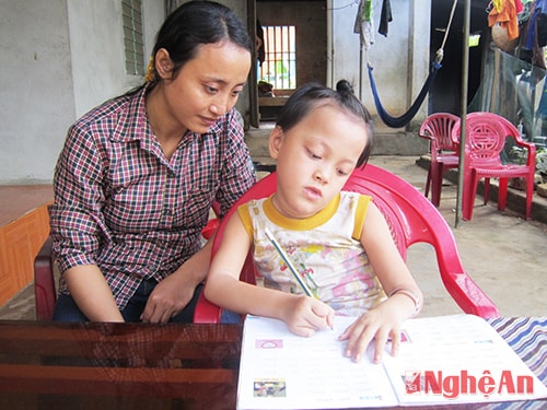 Bảo Lộc được mẹ hướng dẫn tập viết.