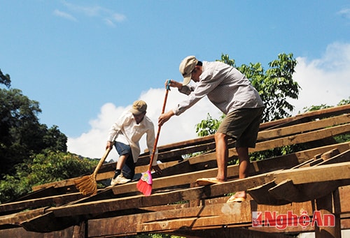 Các thầy giáo lau dọn trên mái nhà.