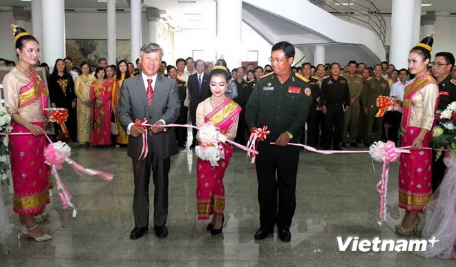 Đại sứ Nguyễn Mạnh Hùng và Trung tướng Souvon cắt băng khai mạc triển lãm ảnh về Quân tình nguyện Việt Nam. Ảnh: Vietnam+