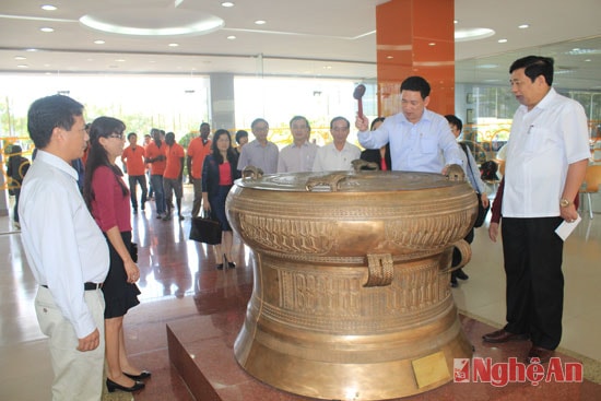 Sảnh lớn của trường có trống đồng lớn, đại diện đoàn công tác đánh trống trước khi vào khảo sát khu vực trường