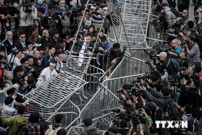 Nhân viên an ninh Hong Kong tháo dỡ các rào chắn do người biểu tình dựng lên bên ngoài tòa tháp CITIC ở Hong Kong ngày 18/11. (Nguồn: AFP/ TTXVN)