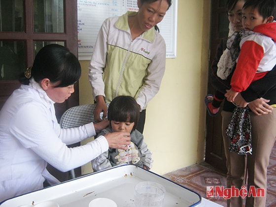 Cho trẻ uống thuốc tẩy giun tại trạm y tế xã Quỳnh Văn