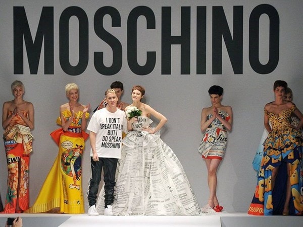 NTK Jeremy Scott (áo trắng quần đen) cùng người mẫu Lindsey Wixson chào khán giả cuối show diễn bộ sưu tập Thu Đông 2014-15 của Moschino.