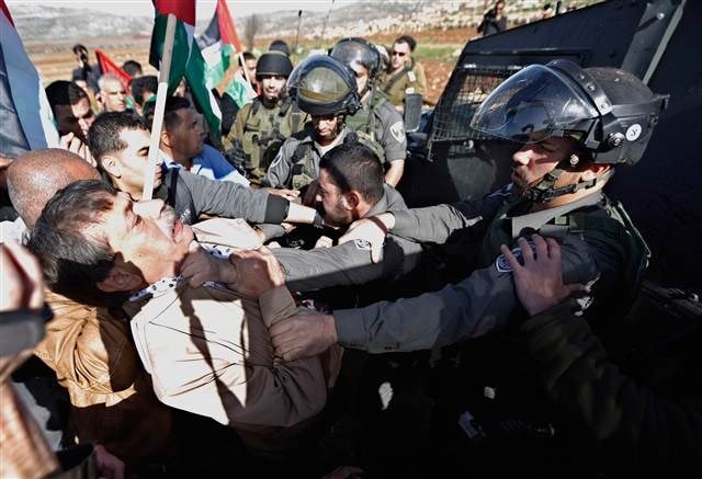 Ông Ziad Abu Ein (áo trắng - trái) bị binh sỹ Israel ngăn cản ở Ramallah, Bờ Tây. (Nguồn: Reuters)