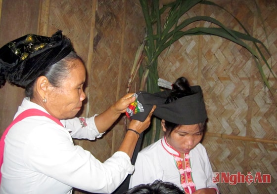 Bà mối làm lễ buộc khăn lên đầu cho cô dâu trong một đám cưới người Thái  ở Lục Dạ - Con Cuông.