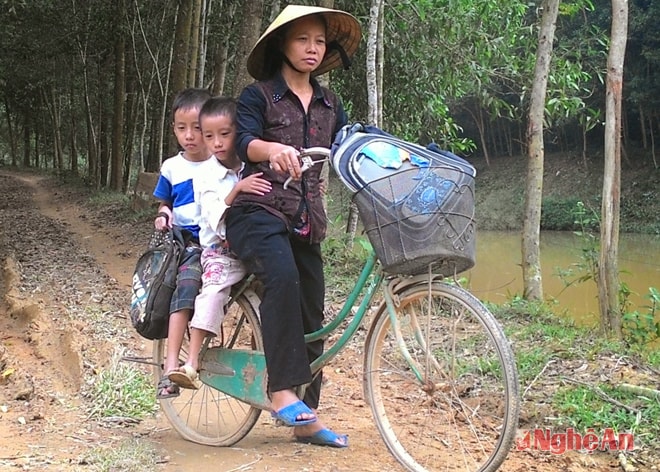 Chị Hà chở 2 con đi học.