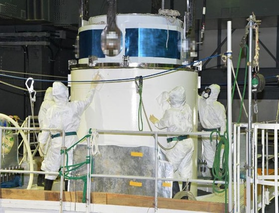 Các kỹ sư của công ty Tepco đang rút các thanh nhiên liệu tại hồ chứa của lò phản ứng hạt nhân số 4 hôm 20/12. Ảnh: Pool/AFP