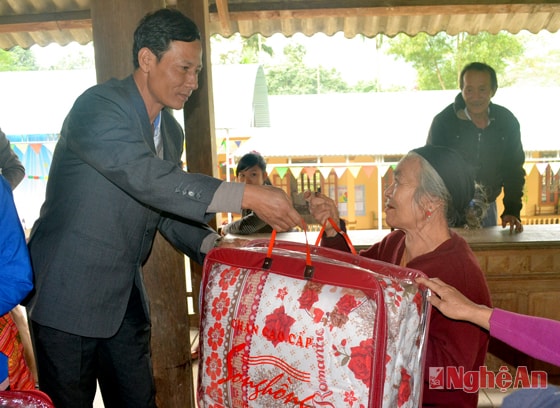 Trao tặng chăn cho bà con. 