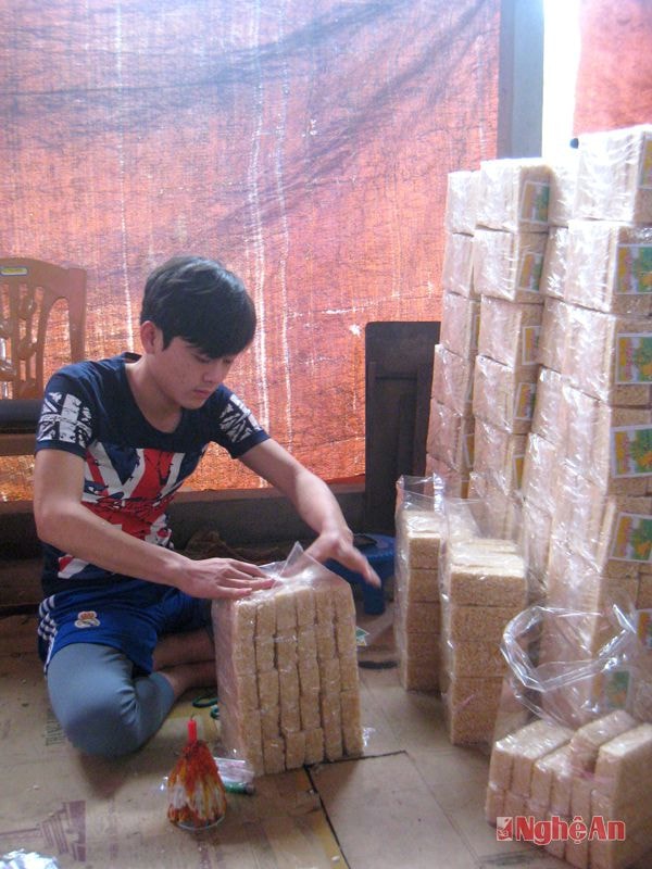Một người thợ đang đóng gói sản phẩm cốm.