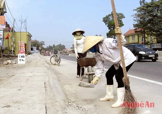 Công nhân của các đơn vị thi công dọn vệ sinh mặt đường Quốc lộ IA