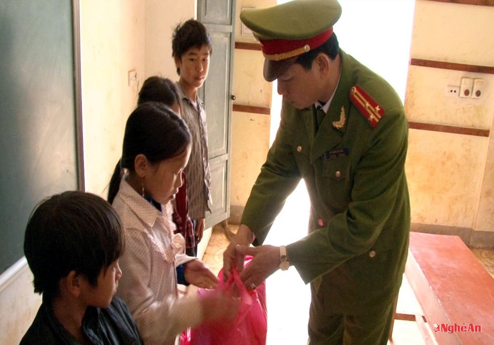 Thượng tá Bùi Minh Quang trao quà cho các em học sinh