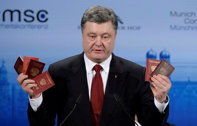 Tổng thống Ukraine Petro Poroshenko cầm trên tay các cuốn hộ chiếu Nga tại hội nghị Munich. (Nguồn: AFP)