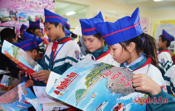 Các em học sinh đọc báo Nghệ An số Tết 2015.
