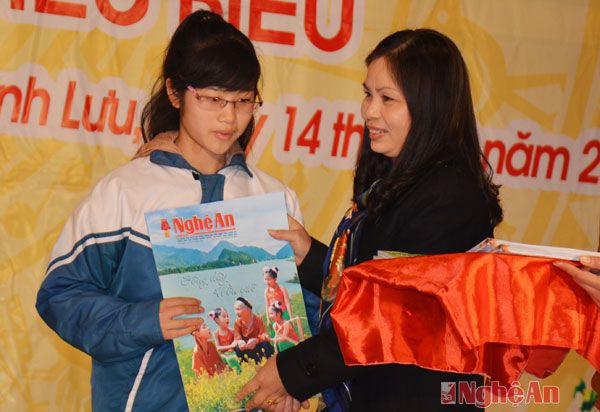 Đồng chí Hồ Thị Ngân, Phó tổng biên tập Báo Nghệ An tặng sổ tiết kiệm cho các em học sinh