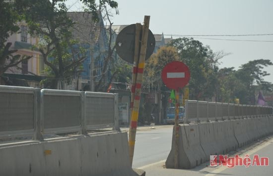 Một tấm biển báo được chống tạm bằng cọc tre, chờ sửa chữa.