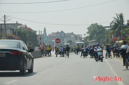 Vào giờ tan tầm, các em học sinh qua đường một cách lộn xộn, nhiều em đi ngược chiều.