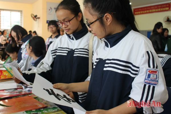 Các bạn trẻ ngắm nghía bức thư pháp đầu xuân của mình