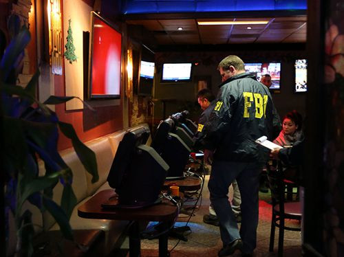 Nhân viên FBI tịch thu các máy đánh bạc ở quán cafe Xinh Xinh. Ảnh: SJMC