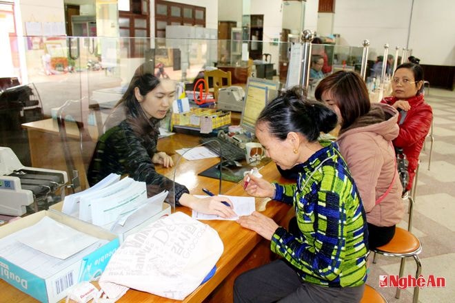 Nhân viên Ngân hàng NN&PTNT Quỳ Hợp  hướng dẫn người dân làm thủ tục giao dịch.