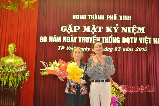 Đồng chí Nguyễn Xuân Sinh - Chủ tịch UBND thành phố Vinh tặng hoa cho Dân quân tự vệ chống Mỹ