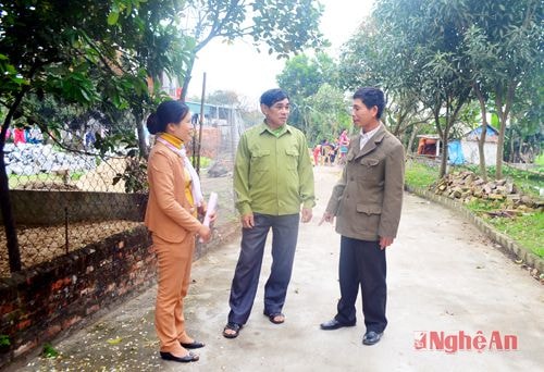 Ông Nguyễn Quang Uy (đứng giữa) đang trao đổi với cán bộ xóm và xã về sự thuận lợi của con đường giao thông NTM