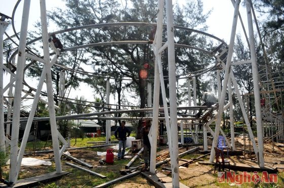 Các công nhân đang khẩn trương lắp đặt trò chơi tàu lượn trên không