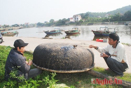 Hai cha con gia cố, sửa thuyền thúng để đi câu mực đêm.