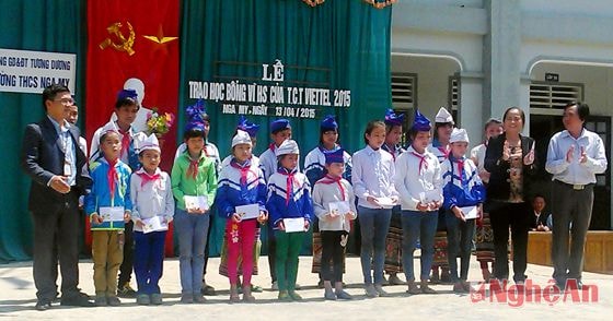 Đại diện công ty Viettel, bà Kha Thị Hoan - Phó chủ tịch Hội Khuyến học và thầy Hồ Duy Thịnh - Phòng GD&ĐT huyện trao học bổng cho các em.