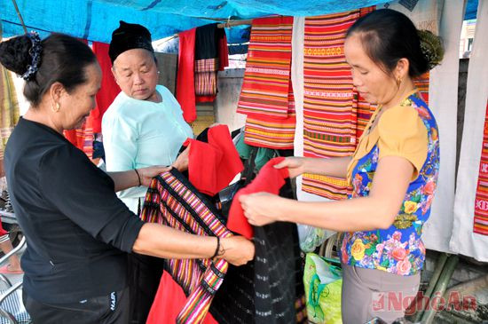 Bà con dân tộc Thái tranh thủ xem sản phẩm dệt thổ cẩm của HTX Thủ công- Mỹ nghệ xã Môn Sơn