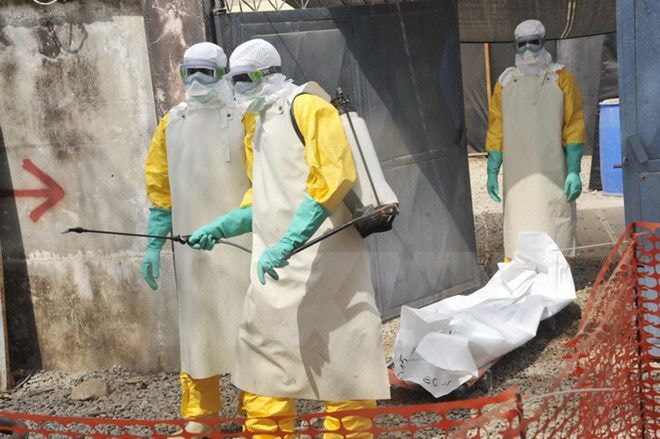     Nhân viên Chữ thập đỏ Guinea chuyển thi thể một bệnh nhân Ebola tại bệnh viện Donka ở thủ đô Conakry ngày 8/3. (Nguồn: AFP/TTXVN)