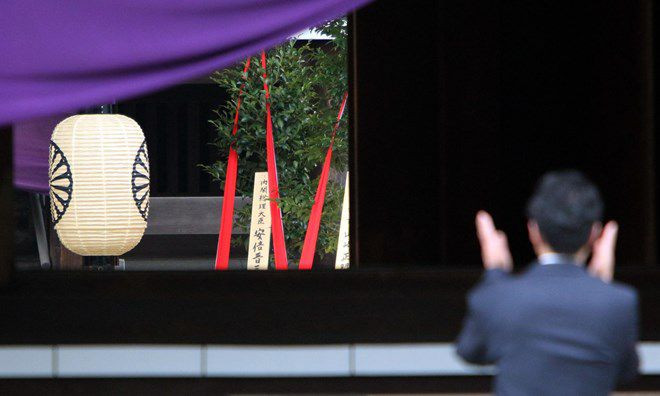 Một người dân Nhật chắp tay trước đền thờ Yasukuni.