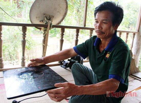 Ông Vi Văn Huệ bên chiếc bếp từ mới mua được.