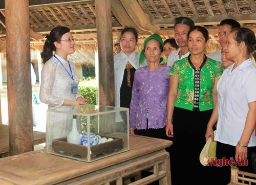 Đoàn khách đến từ huyện Văn Chấn, tỉnh Yên Bái nghe thuyết minh  về quê ngoại Bác Hồ. Ảnh: mỹ hà