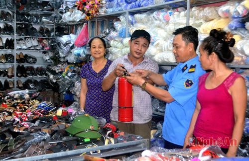 Cán bộ BQL Trung tâm thương mại chợ Đô Lương hướng dẫn hộ kinh doanh sử dụng bình chữa cháy