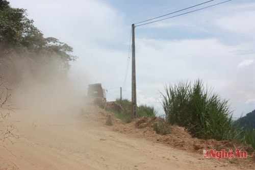 Một chiếc xe tải lên dốc bụi phun mù trời.